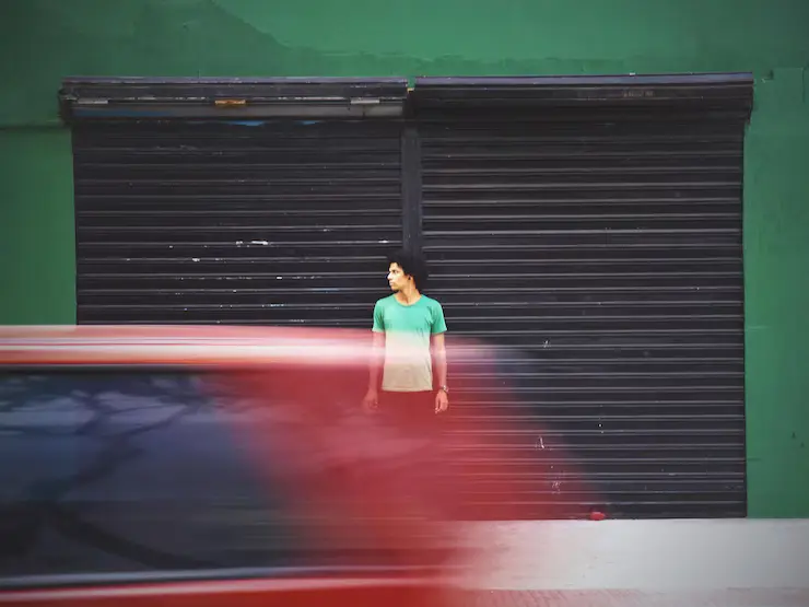 Uskarpe bevegelser av en bil på veien mot en mann som står i en garasje