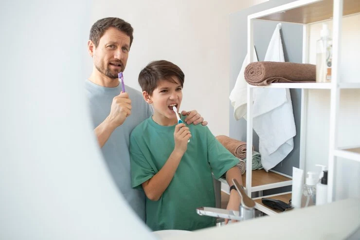 mann og gutt pusser tenner